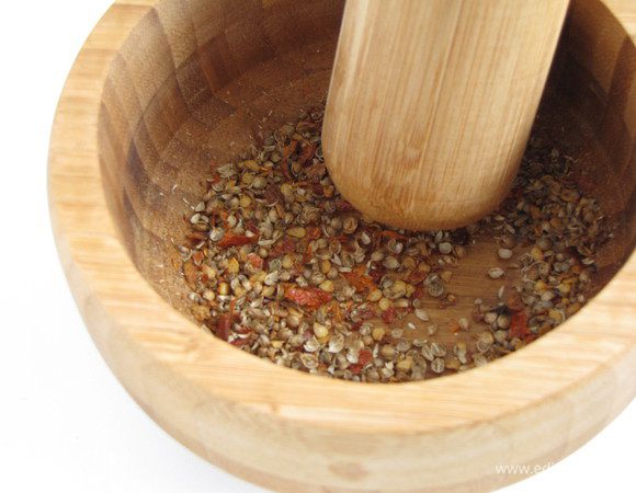 Кориандр растолочь в ступке. Т.к. у меня были целиком засушенные перчики чили, я растолкла их вместе с кориандром.