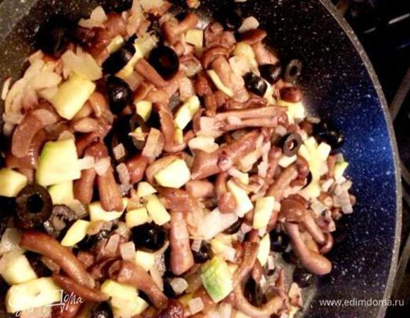 Начинка: Опята очистить, промыть, отварить в кипящей подсоленной воде в течение 3—4 минут, откинуть на дуршлаг, дать воде стечь, порезать и обжарить на сливочном масле.-Мелко нарезать кабачок, оливки, лук, чеснок, добавить к грибочкам и жарить до готовности.