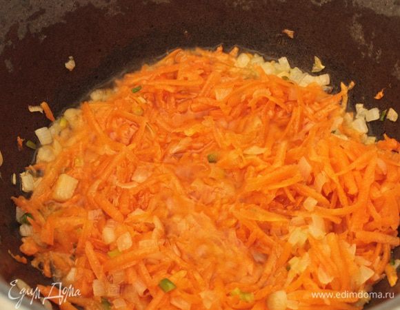 Я готовлю блюда такого типа в казане,т.е. все продукты обжариваю в нем же.Вы можете обжаривать на сковороде и потом тушить в удобной для вас посуде.Луковица и морковь средней величины.Репчатый лук нарезать мелким кубиком,морковь натереть на крупной терке.Казан нагреть на среднем огне,налить растительное масло. Пассировать лук до прозрачности(2-3 минуты), добавить морковь,помешивая,обжаривать еще 5-7 минут.