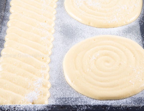 Отсадить с помощью кондитерского мешка с круглой насадкой диаметром 1 см на противень, застеленный пергаментом или на силиконовый коврик, 2 диска диаметром 19 см. И еще отсадить полоску шириной 10 см и длинной 40 см, двигая насадкой мешка по диагонали.