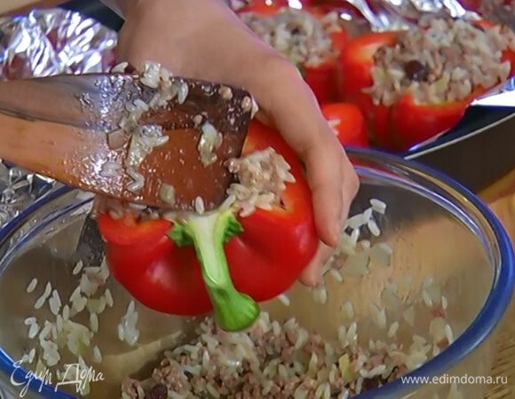 Форму выстелить фольгой, выложить половинки перца, начинить их фаршем и посыпать сверху кедровыми орехами.