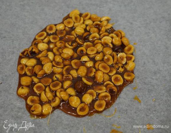 Орехи всыпать в карамель, перемешать, вылить массу на пергамент, поставить в холодное место, чтобы застыла.