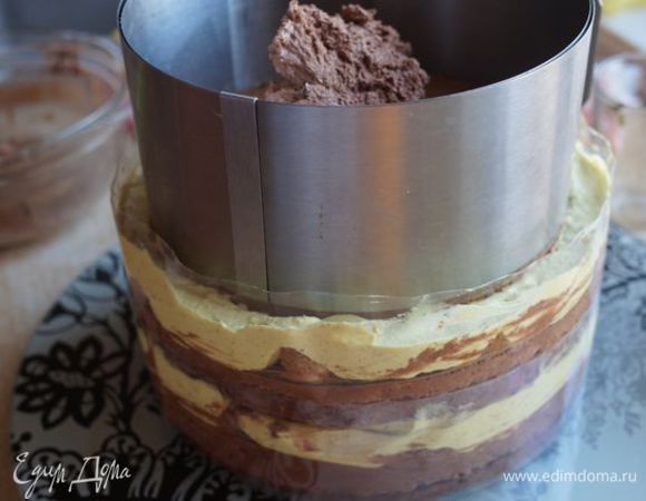 Продолжаем в таком же порядке с коржом 26 см, переставляем тортовое кольцо, покрываем корж 18 см ганашем, кранчем и кремом.