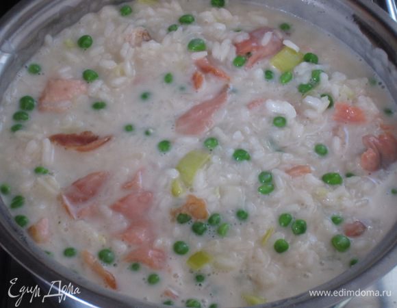 Через 10 минут добавить размороженный горошек,филе лосося,влить сливки и готовить на среднем огне под крышкой. За 3-5 минут до готовности добавить копчёный лосось,посолить,поперчить .