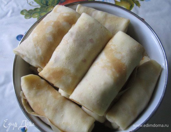 На каждый блинчик выкладываем ложку начинки и сворачиваем конвертом. 