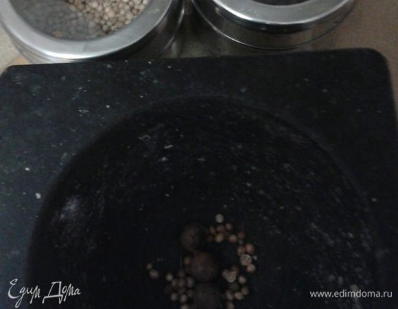 Толкушкой растолочь семена кориандра и душистого перца. 