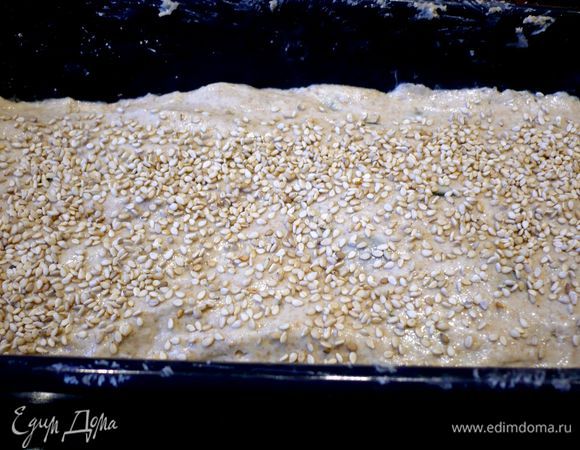 Форму смажем маргарином или маслом, присыпем слегка мукой. Выложим тесто в форму и мокрой рукой разровняем верх, сверху посыпем кунжутом. Ставим выпекаться в холодную духовку при 220 градусах на 50 минут. Через 30 минут прикрываем форму пергаментом. Выпекаем еще полчаса.