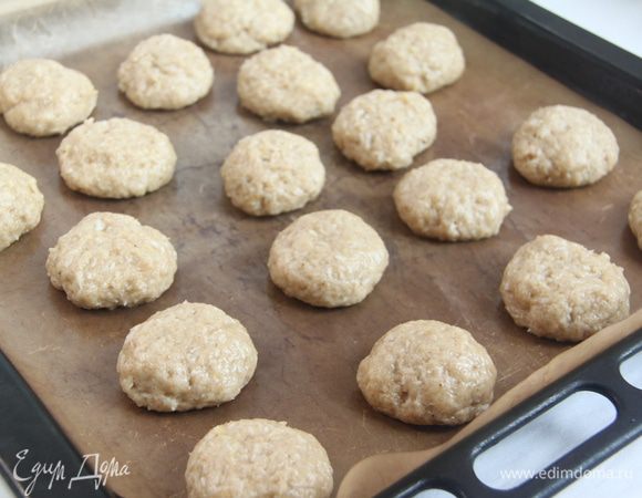 Смачивая руки водой, сформировать из теста небольшие колобки, выложить их на антипригарный противень, слегка придавить. Выпекать примерно 15 минут.