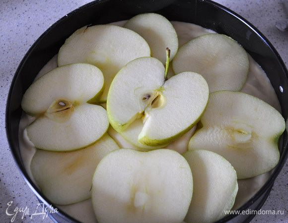 Залить тестом. Уложить сверху порезанное кружками яблоко.