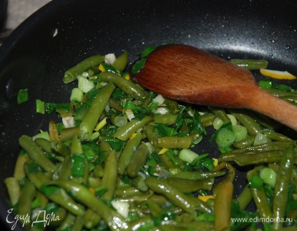 На разогретую сковороду выкладываем спаржевую фасоль, немного обжариваем, режем зеленый лук произвольными кусочками и добавляем на сковороду, солим и перчим по вкусу.