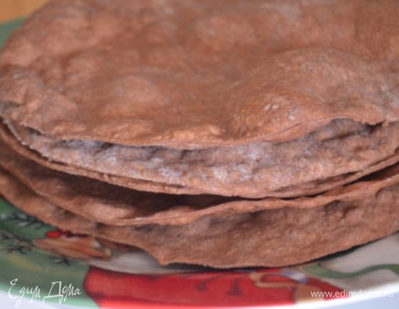 Перенести круг на бумагу для выпечки и выпекать 7 минут при 200 гр. При этом надо ОБЯЗАТЕЛЬНО часто наколоть вилкой тесто, чтобы оно не вздыбилось. Складываем стопкой коржи. Обрезки можно собрать и раскатать опять, выпечь корж чуть подольше - минут 10, чтобы он прям подсох и раскрошить для оформления. 