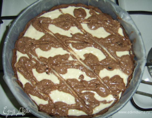 Разогреть духовку до 180 г и поставить форму с основой на 15-20 мин. Все-таки стоит выложить на тесть груз (горох, например), иначе дно теста вздуется. Ничего страшного, конечно, в этом нет, можно проткнуть вилкой, и все опять осядет. 
Затем на основу выложить начинку, украсить шоколадной начинкой сверху и отправить в духовку на 45-55 мин (чиз готов, когда бока схватились, а серединка еще подрагивает). Выключить духовку, но оставить чизкейк до полного остывания в духовке, затем отправить на 2 ч в холод, потом освободить из формы и подавать.