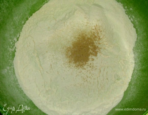 Вечером  просеять в миску муку, добавить дрожжи, соль и сахар, перемешать. Влить воду, перемешать ложкой до однородности. Миску с тестом затянуть плёнкой или укрыть полотенцем и оставить до утра.  
