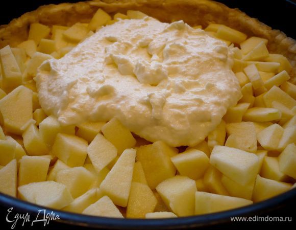 Теперь на тесто выложим половину яблок. Сверху выложим чуть меньше половины сливочной заливки, распределим заливку по яблокам. 