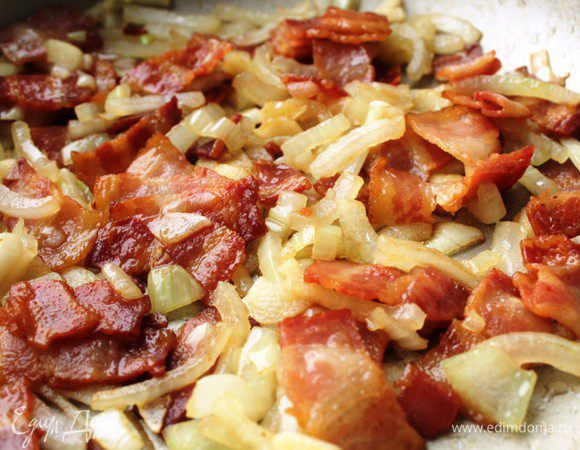 Добавить к бекону рубленый лук и чеснок. Жарить до мягкости 2-3 минуты.
