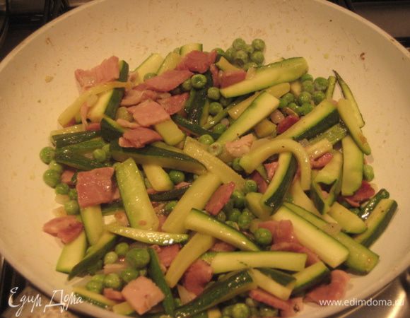 Добавить замороженный зеленый горошек (предварительно не размораживать), обжарить 5 минут.  Посолить, поперчить. Добавить белое вино, дать вину выпариться. 