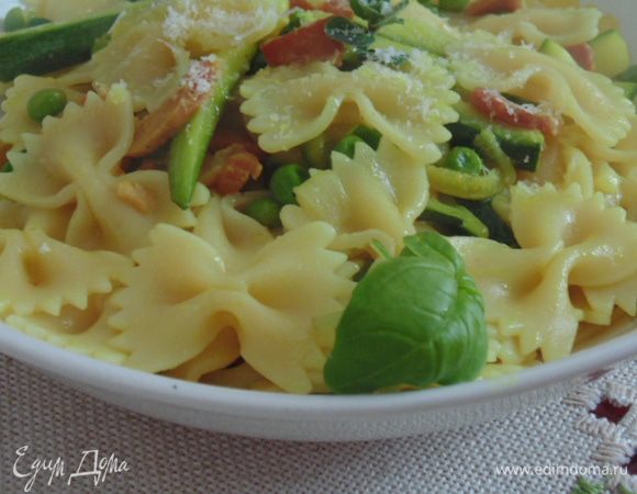 Готовую пасту откинуть на дуршлаг, сохранить пару ложек воды, в которой варилась паста. Пасту и воду добавить к смеси, перемешать. Разложить по тарелкам. Посыпать тертым пармезаном.