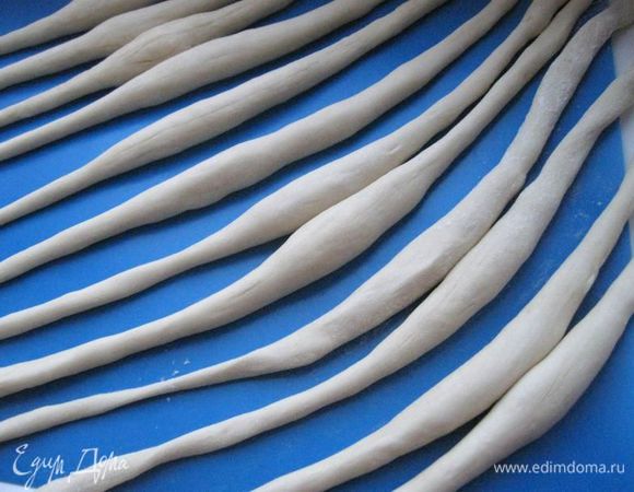 Каждую часть раскатать обеими руками в «колбаску» длиной примерно 46-50 см с утолщением в средней части. 