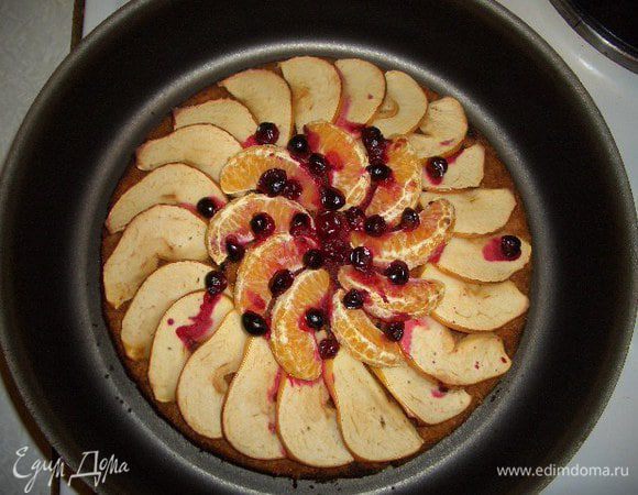 Достать пирог и украсить его тонко нарезанным яблоком, дольками мандарина и клюквой. Поставить снова в духовку на 10-15 минут. Готовый пирог немного остудить, посыпать сахарной пудрой перемешанной с корицей.