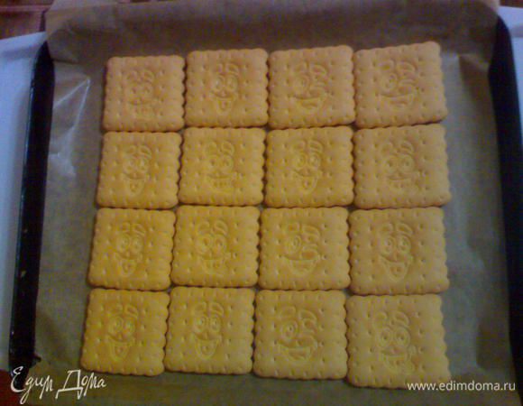 Включаем духовку на 180 градусов, застилаем противень промасленной пергаментной бумагой и выкладываем первый слой печенья.