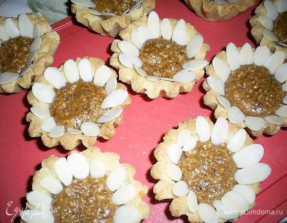 Молотый миндаль смешиваем  с карамелью и наполняем остывшие корзиночки. В принципе, на этом этапе уже можно остановиться и приступить к чаепитию))) А можно выложить лепесточки из миндальных лепестков...