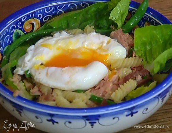 Выложить в салатницу немного листьев салата, затем макароны с тунцом и оставшийся салат, сбрызнуть оливковым маслом, а сверху поместить яйцо пашот, слегка разломив его вилкой.
