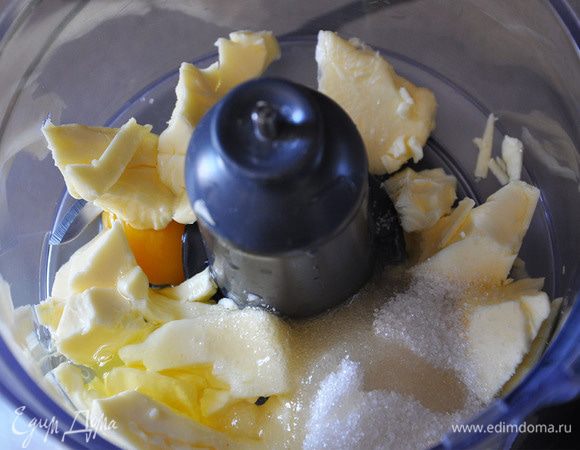 В чашу комбайна положить мягкое сливочное масло, насыпать сахар и вбить яйцо. Размешать.