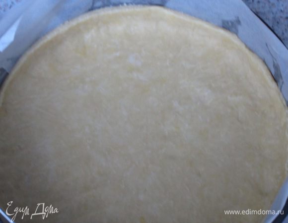Тесто тонко раскатать (удобнее раскатывать между двумя листами пергамента) и выложить в форму диаметром 24 см с пергаментом.