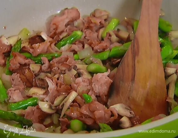 Когда грибы будут готовы, добавить в сковороду спаржу, перемешать и обжаривать 3–4 минуты.