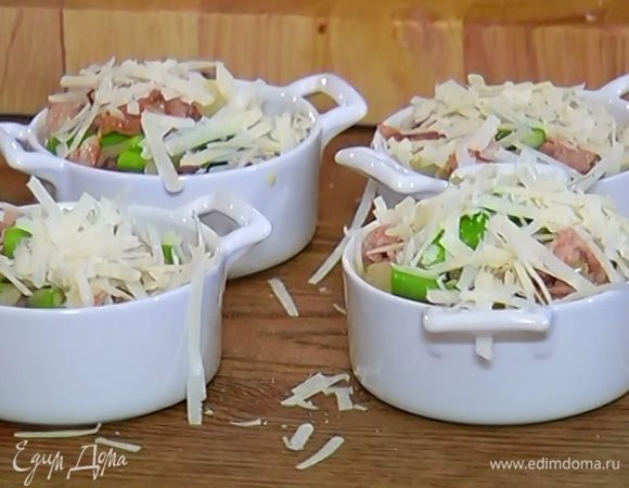 На дно небольших керамических форм выложить кусочки хлеба, разлить яичную массу с грибами и спаржей и посыпать сыром.