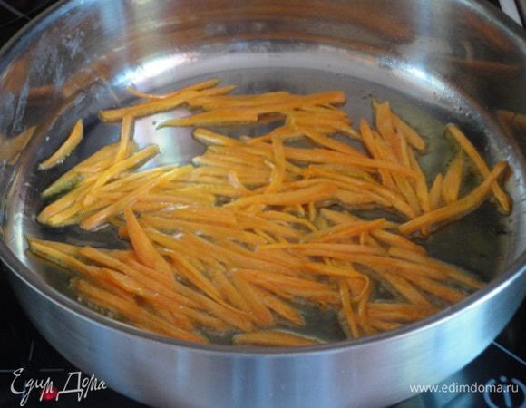 Морковь очистить и нарезать соломкой. Половину растительного масла разогреть в сковороде и обжарить морковь до мягкости.