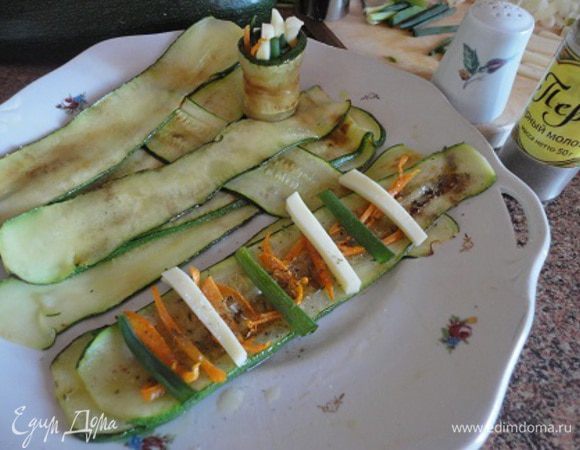 Зелень лука, морковную соломку и сыр выложить на ломтики цуккини. Посолить, поперчить, посыпать орегано и тимьяном, скатать рулетики. Можно сколоть, но я этого не делала.