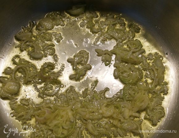 Небольшую луковицу нарезать. Чеснок мелко порубить. В кастрюле с тяжелым дном разогреть оливковое масло и положить обжариваться лук.