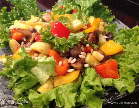 На листья салата выложите овощи, посолите, поперчите по вкусу, сверху посыпьте кедровыми орешками.