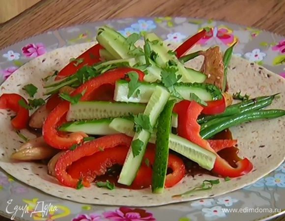 На тортилью выложить индейку с фасолью и соусом, сверху поместить сладкий перец и огурец, посыпать все кинзой. Свернуть лепешку в рулет и разрезать пополам.