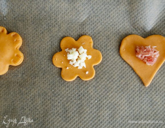 Одну половинку "пирожка" выложить на пекарскую бумагу или силиконовый коврик. Сверху положить немного начинки... 