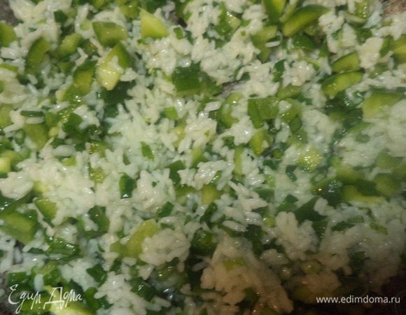Добавить к рису зеленый перец и зеленый лук, перемешать. Поставить на слабый огонь и варить, периодически помешивая, пока жидкость полностью не впитается, около 5 минут.
Рис должен получиться плотным и рассыпчатым, а овощи остаться хрустящими.