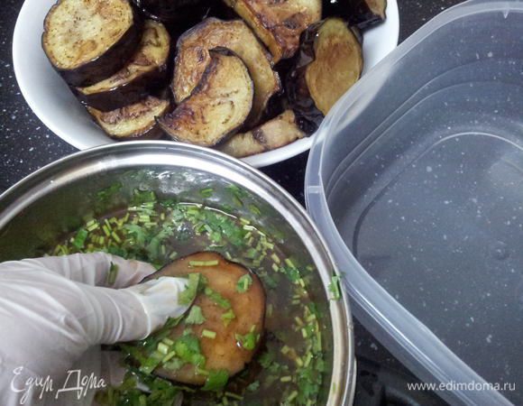 Окунаем каждую половинку баклажана, чтобы кинза окутала баклажан равномерно. Почему каждую половинку отдельно и не перемешиваем сразу? Потому что жареный баклажан мягкий, и если перемешать, то может все развалиться и потеряется вид. Складываем в пустую емкость. Далее оставшийся маринад выливаем сверху.