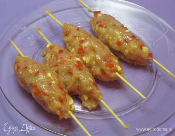Из фарша сформовать колбаски длиной 10 см. Нанизать на деревянные шампуры.