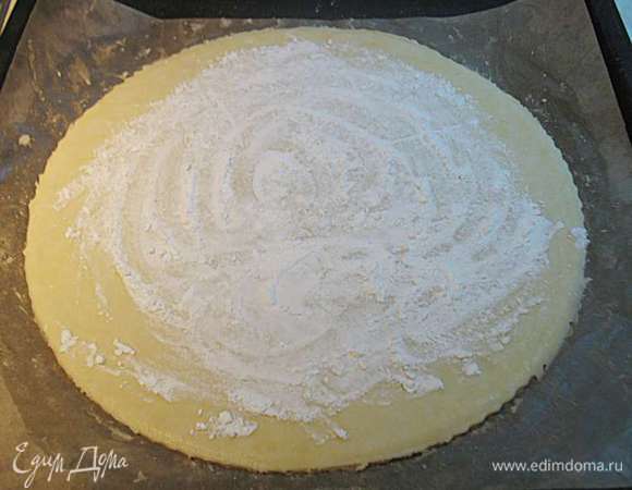 Вынуть тесто из холодильника и на пекарской бумаге поместить на противень.  У меня в первый раз тесто в духовке отказалось держать форму, поэтому я его стала помещать в форму для киша (возможно это произошло из-за того, что слива заморожена). Посыпать тесто крахмалом, это нужно для того чтобы тесто не мокло от сока и оставалось хрустящим. 