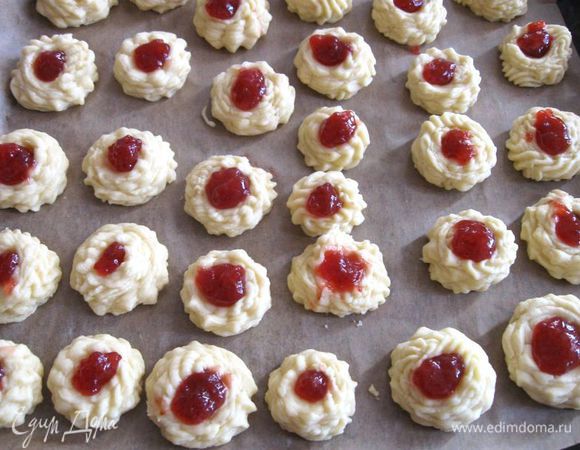 Мокрым пальцем сделать в каждом печенье углубление и положить туда джем, в который добавлен крахмал (чтобы не растекалась начинка) в  пропорции 10: 1. Выпекать печенье при  200 градусах  20  минут. Минут через 15 проверить печенье, вам может потребоваться немного меньше времени.