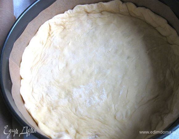 Застелить форму и бортики бумагой для выпечки. Положить раскатанное тесто на дно.