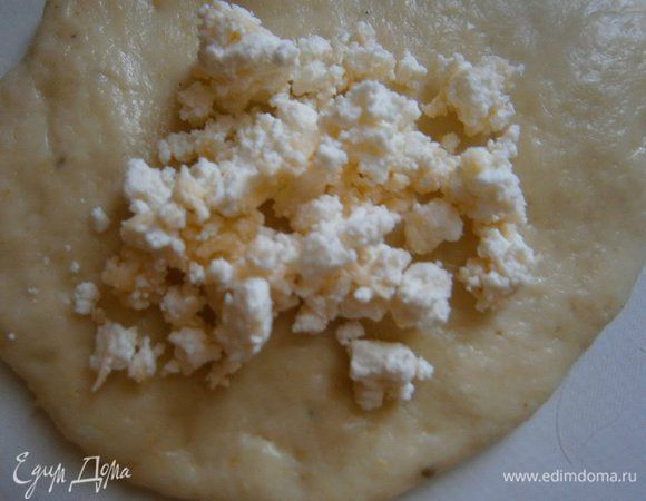 Каждую часть теста руками растянуть в лепешку, выложить начинку и хорошо защипнуть. Сформировать круглые булочки.