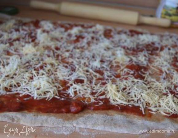 Тонким слоем распределить часть томатного соуса, присыпать сыром.
