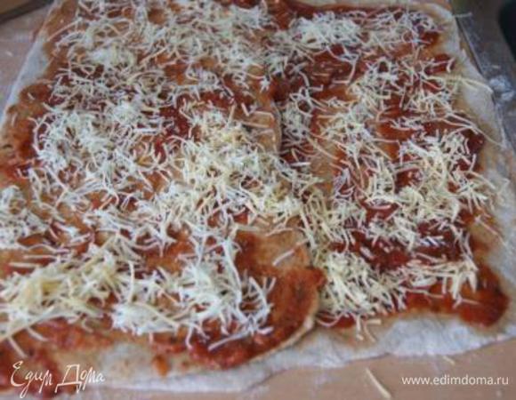 Покрыть тонким слоем томатной пасты, присыпать сыром.