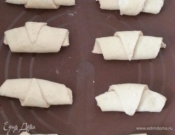 Выкладываем на силиконовый коврик или пергамент, смазанный маслом. Накрываем полотенцем, включаем духовку на 180С. Смазываем круассаны смесью желтка и 3 ст.л. молока, после нагрева отправляем круассаны выпекаться на 30 минут, до легкого румянца, важно их не пересушить. Со второй частью теста поступаем аналогично.