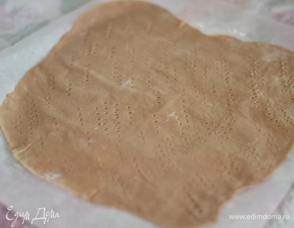 Теперь займемся коржами. Раскатать колобок на пергаменте,присыпанный мукой очень тонко и наколоть хорошенько вилкой. Выпекать каждый корж около 6-7 минут при температуре 200 градусов.