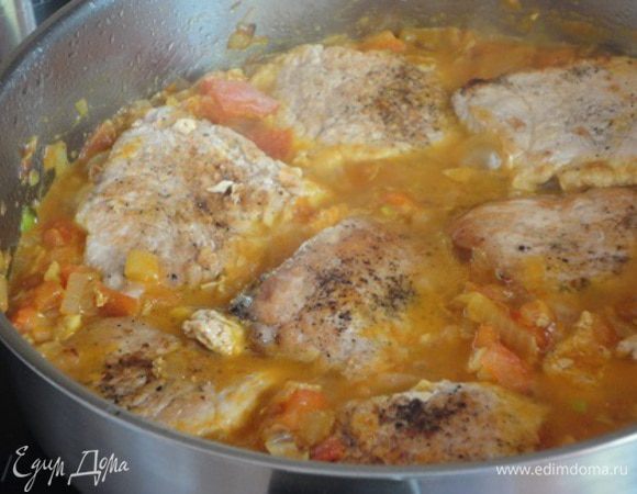 Нашинкованный лук и чеснок обжарить в том же масле, где жарилось мясо. Перед тем, как лук станет золотистого цвета, добавить промытый изюм, затем  очищенные от кожицы и семян и нарезанные помидоры и порошок карри. Прожарить пару минут.
Положить свинину опять в сковороду и залить вермутом и бульоном. Готовить 10 минут.