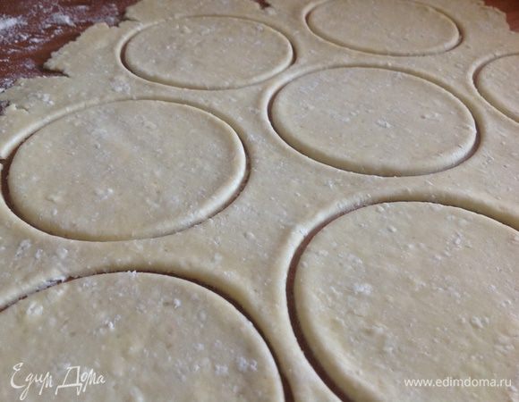 Тесто вынуть из холодильника и раскатать в пласт, толщиной около 3 мм. Вырезать стаканом или формочкой кружочки.