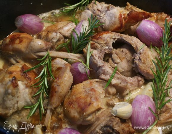 Как только кролик зарумянится, влить белое вино, добавить стакан воды, посолить и поперчить по вкусу. Положить лук, чеснок и розмарин. Накрыть крышкой и тушить на слабом огне 1 час. Пару раз перевернуть кусочки кролика.